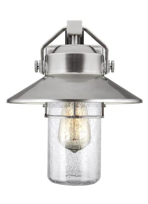 Polished brass outdoor wall lantern with a traditional design and clear seeded glass panels.