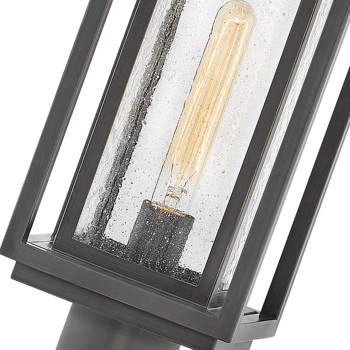 A close-up of a traditional outdoor wall lantern with an oil-rubbed bronze finish.