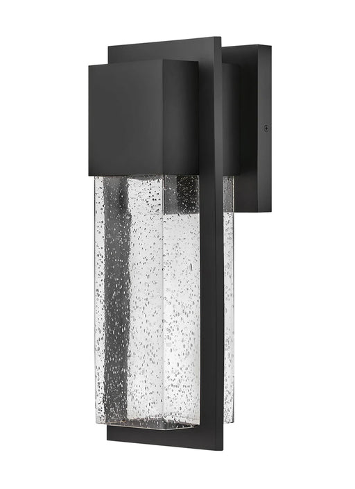 A modern outdoor wall light with a black finish and clear seeded glass featuring a rectangular design.