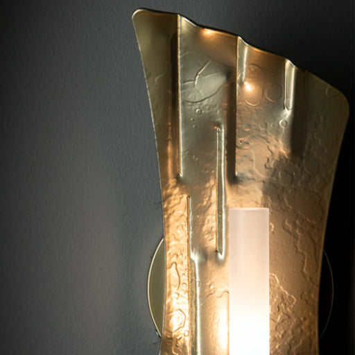 A close-up of a modern ceiling fan with light wood-tone blades.