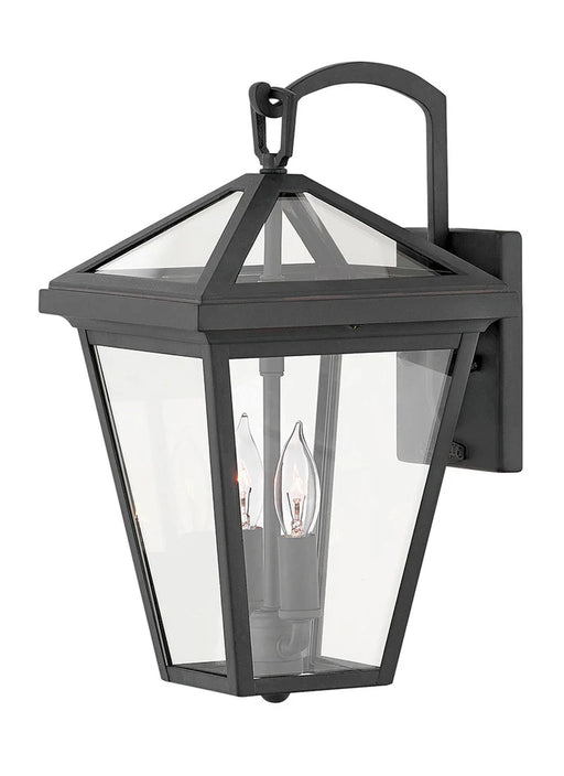 A traditional outdoor wall lantern with a matte black finish and clear seeded glass.