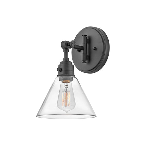 Black wall light with a cylindrical clear glass shade and exposed bulb.