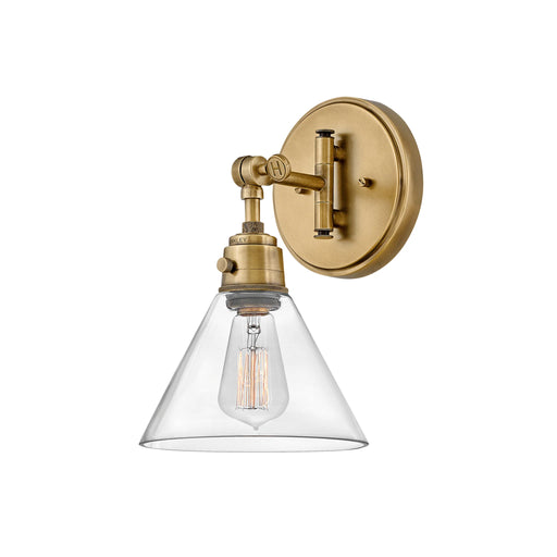 Heritage bronze wall light with a cylindrical clear glass shade and exposed bulb.