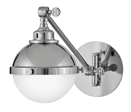 A polished nickel linear pendant light with clear glass shades hanging over a kitchen island.