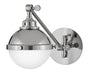 A polished nickel linear pendant light with clear glass shades hanging over a kitchen island.