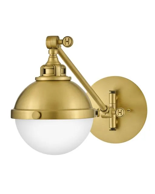A satin brass linear pendant light with clear glass shades illuminating a modern kitchen.