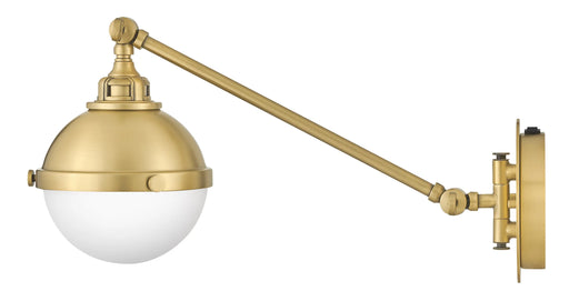 A contemporary linear pendant light with four clear glass shades and a satin brass finish.