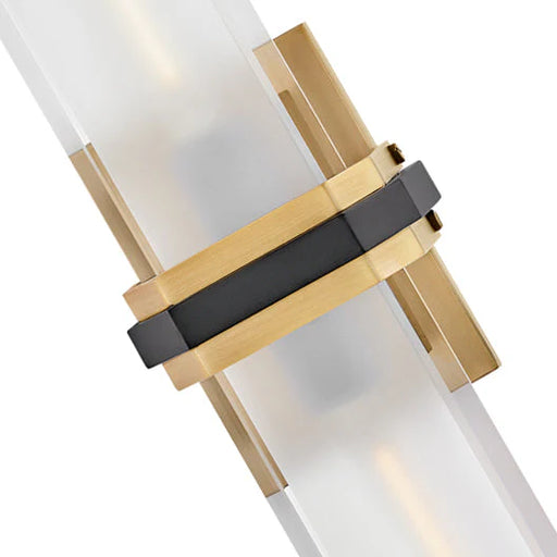 A close-up of a Kipton wall sconce showing the white cylindrical glass shade and black base.