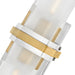 A close-up view of a modern wall sconce featuring a white cylindrical glass shade and a polished nickel base.
