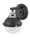 Black and chrome modern wall sconce with an elongated, cylindrical white glass shade, angled view.