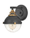 Black modern wall sconce with an elongated, cylindrical white glass shade.