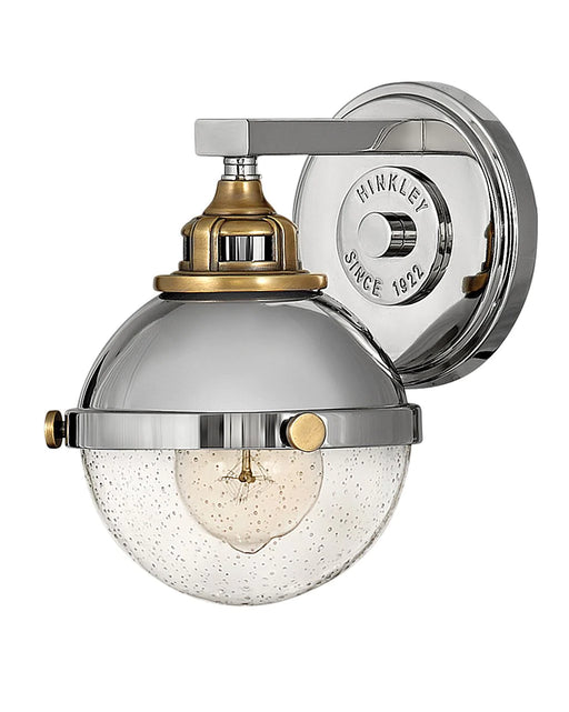 Polished nickel modern wall sconce with an elongated, cylindrical white glass shade.
