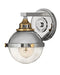 Polished nickel modern wall sconce with an elongated, cylindrical white glass shade.