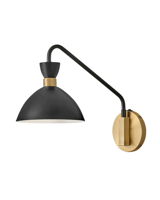 Black and heritage brass wall sconce with a curved arm and cylindrical glass shade.