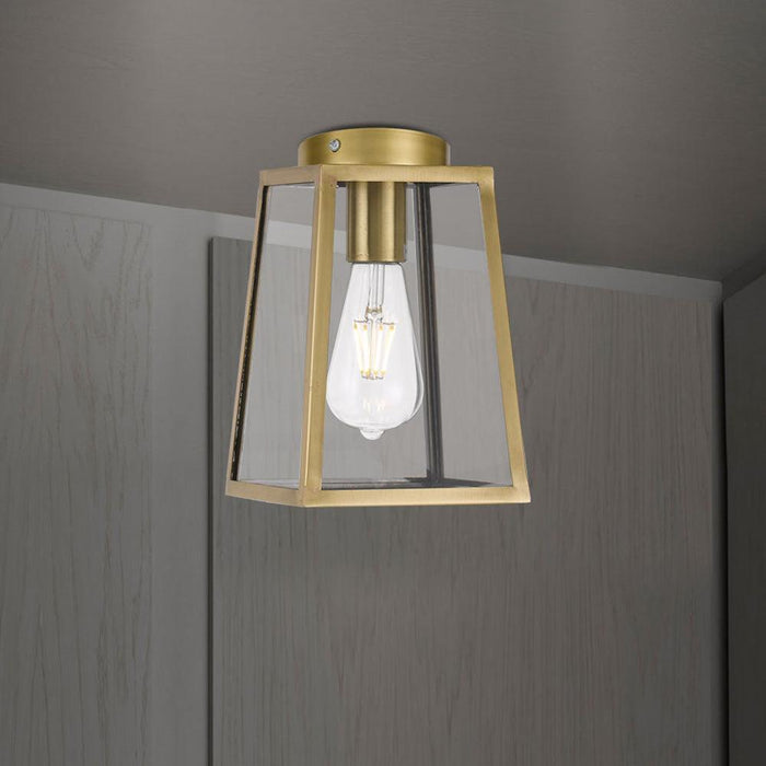 Aged bronze 15-light linear pendant with decorative cages and clear seeded glass panels, close-up of light.