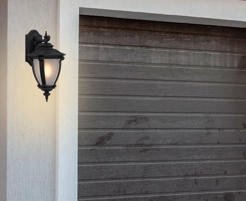 Cropped view of a black outdoor wall sconce with a modern, curved design.
