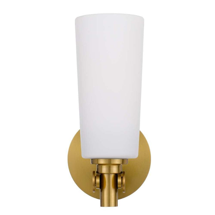 Aged gold outdoor wall sconce with an opal glass panel, illuminated.