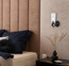 Cropped view of a black outdoor wall sconce with a clear glass panel.