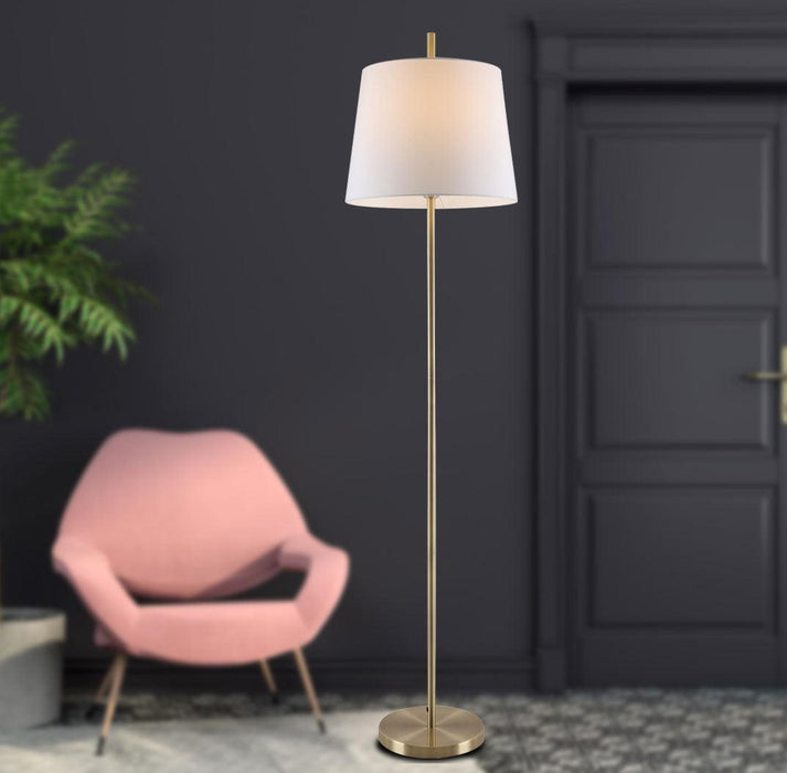 White and aged bronze floor lamp with a spherical glass shade, illuminated.