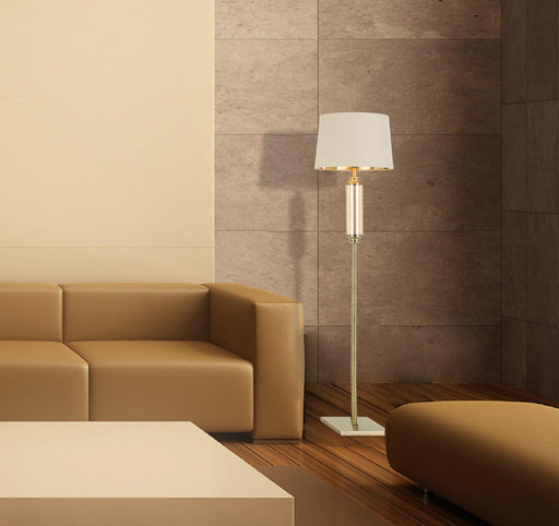 Aged bronze floor lamp with an amber glass diffuser, illuminated.