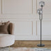 Black floor lamp with a rectangular light panel, illuminated.
