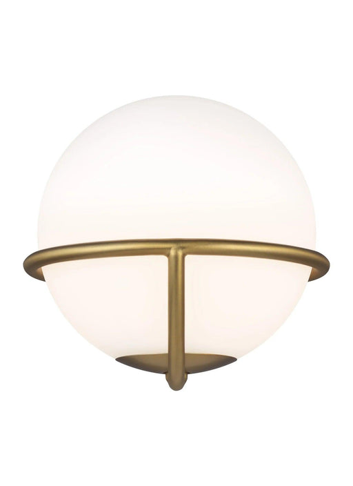 Distressed black and brass modern wall light with a cylindrical clear glass shade, angled view.