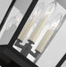 A close-up of a modern textured black outdoor wall light with seeded glass.
