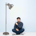 Nickel floor lamp with a cylindrical fabric shade, illuminated.