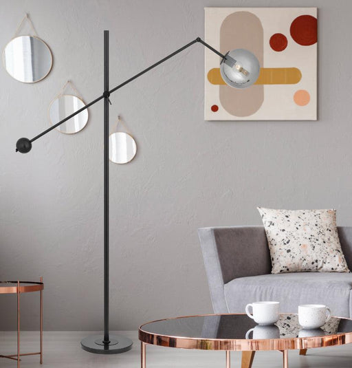 Black and smoky floor lamp with a spherical glass shade, cropped view.