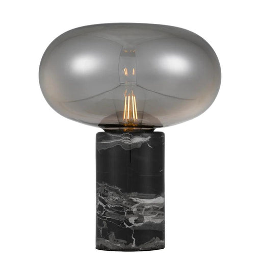 Black and smoky table lamp with a cylindrical base and a spherical glass shade.