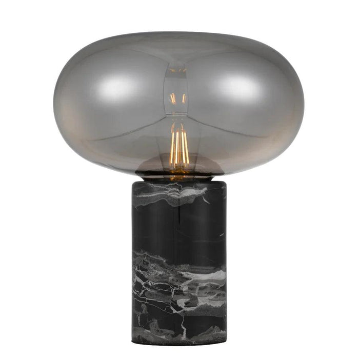 Black and smoky table lamp with a cylindrical base and a spherical glass shade.