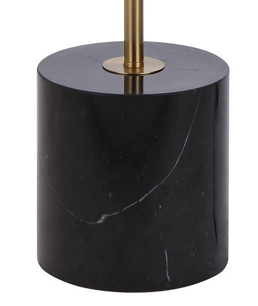 Close-up of the black and aged gold base of a floor lamp.