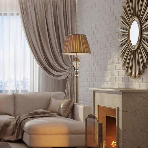 Aged gold floor lamp with a rectangular fabric shade, illuminated.