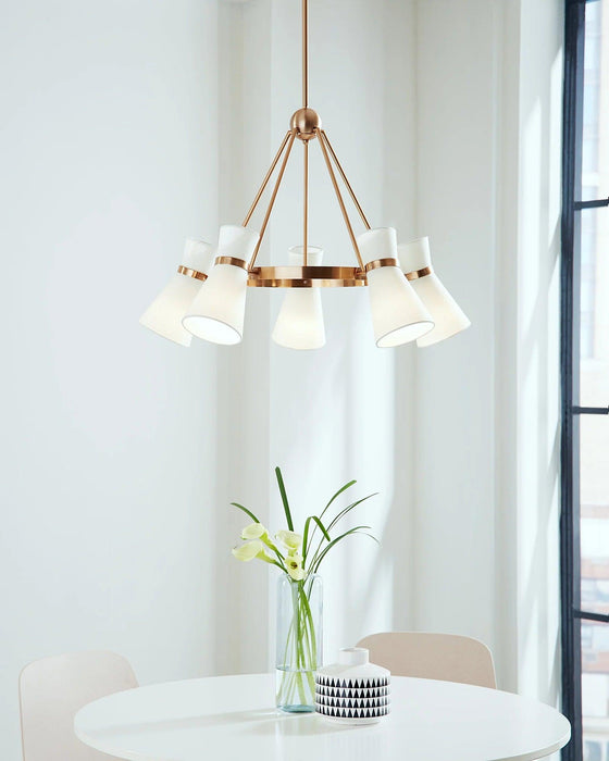 Bronze modern linear chandelier with five cylindrical clear glass shades, in a dining room setting.