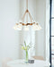 Bronze modern linear chandelier with five cylindrical clear glass shades, in a dining room setting.