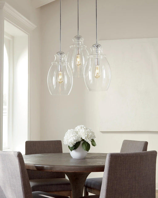 Chrome pendant light with a clear bell-shaped glass shade, in a room setting.