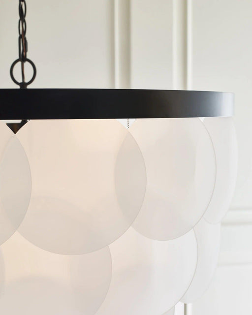 Brushed nickel modern chandelier with six spherical white glass shades, in a dining room setting.
