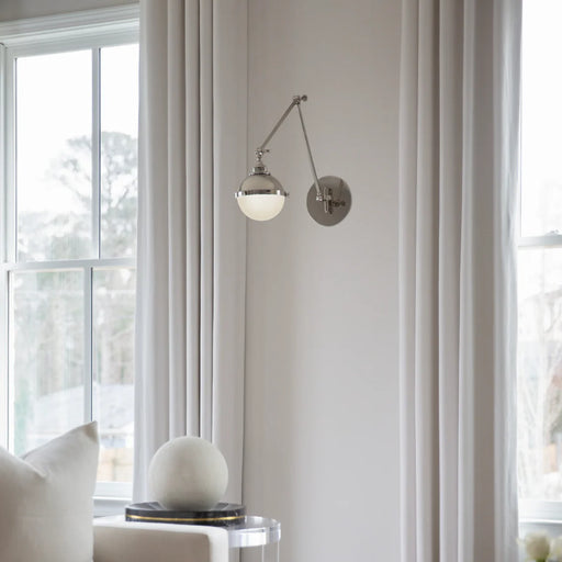 A polished nickel linear pendant light with clear glass shades illuminating a dining room.