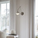 A polished nickel linear pendant light with clear glass shades illuminating a dining room.