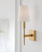 Distressed black wall sconce with a cylindrical light source, in a classic setting.