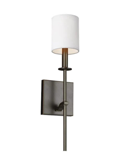 Antique bronze wall sconce with a cylindrical clear glass shade and exposed bulb.
