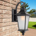 Black outdoor wall sconce with a modern rectangular design, illuminated.