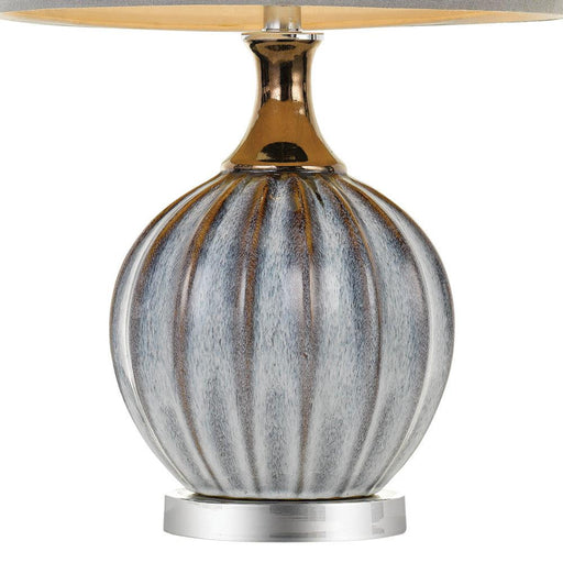 Aged bronze and white table lamp with a cylindrical base and a conical fabric shade.