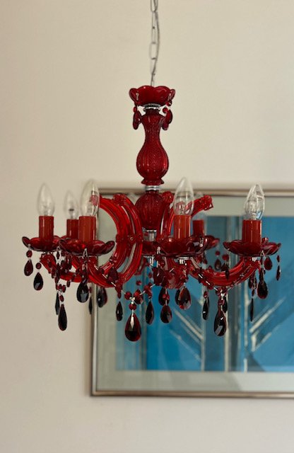 Modern black linear chandelier with multiple exposed bulbs and a rectangular frame, close up.