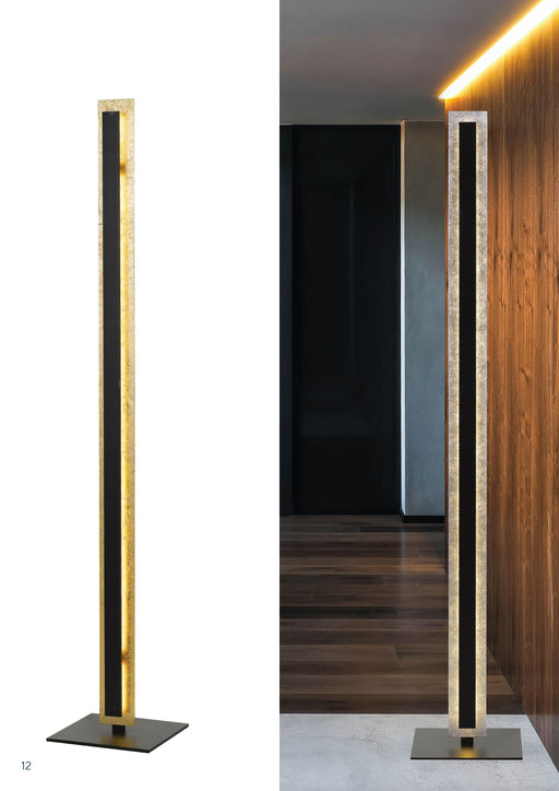 Gold floor lamp with a cylindrical fabric shade, illuminated.